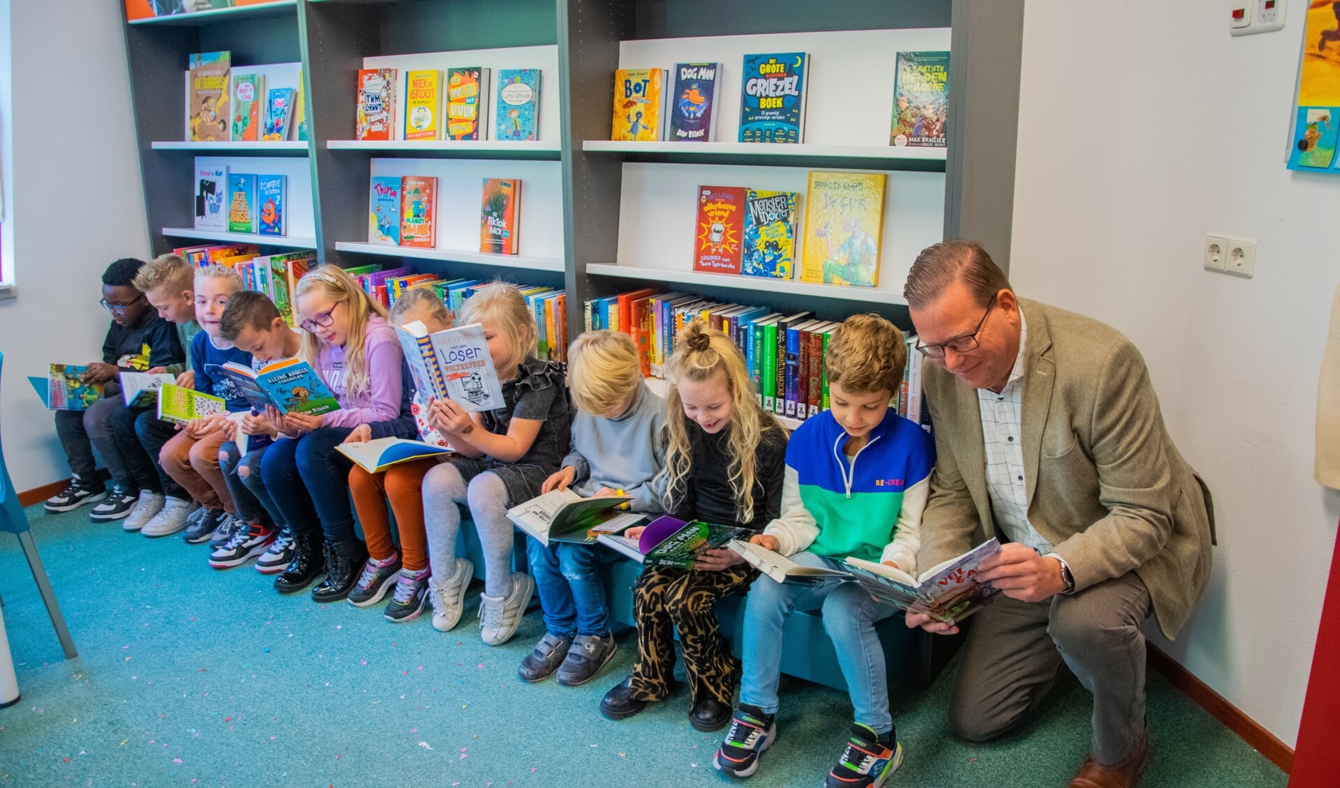 Na de opening mochten de kinderen, en de wethouder, meteen even een boekje uitzoeken om te lezen.  Foto: Sam Fish