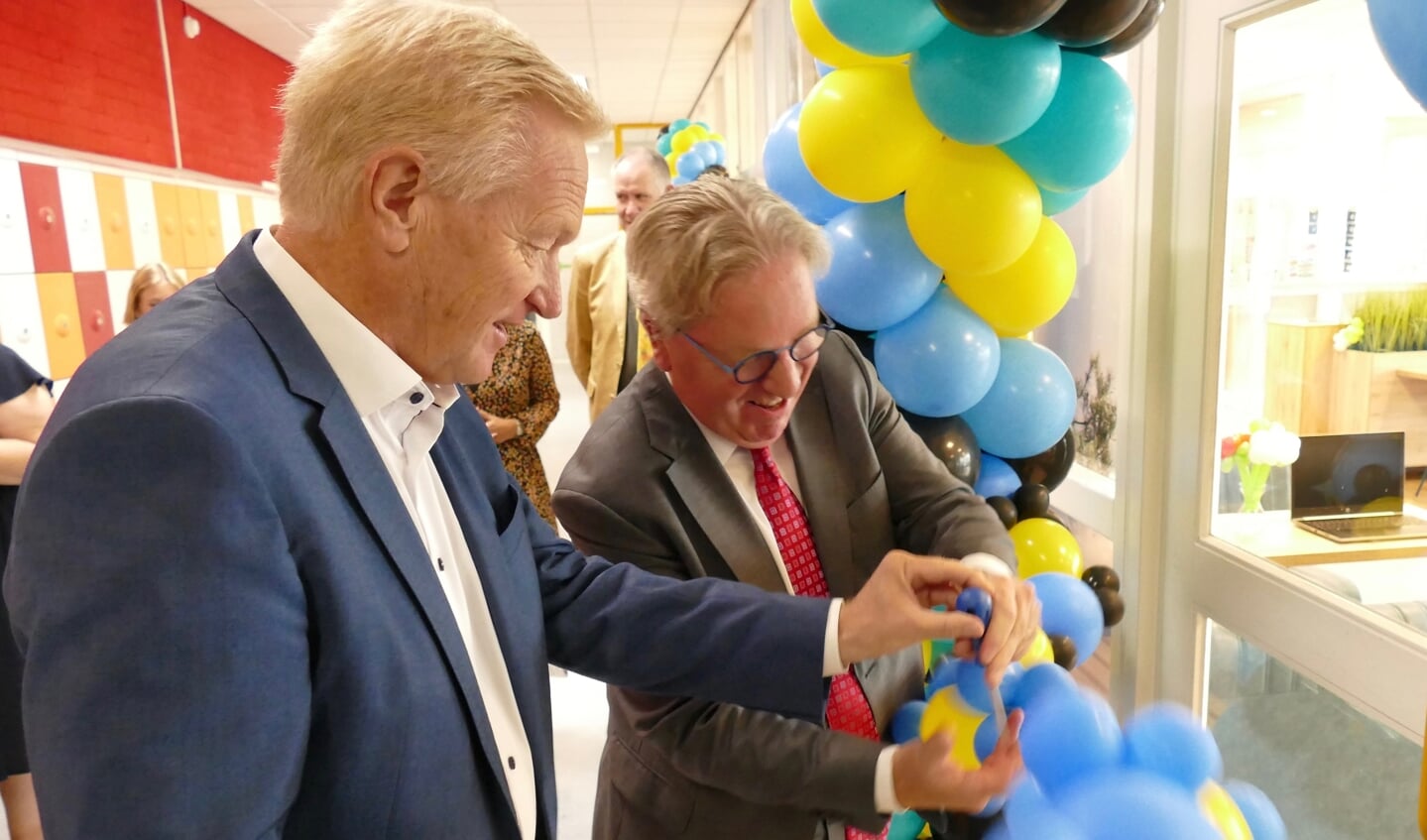 Wethouder Hans van der Velde prikte samen met rector Benedict Hamans, symbolisch in een ballon voor de feestelijke opening.