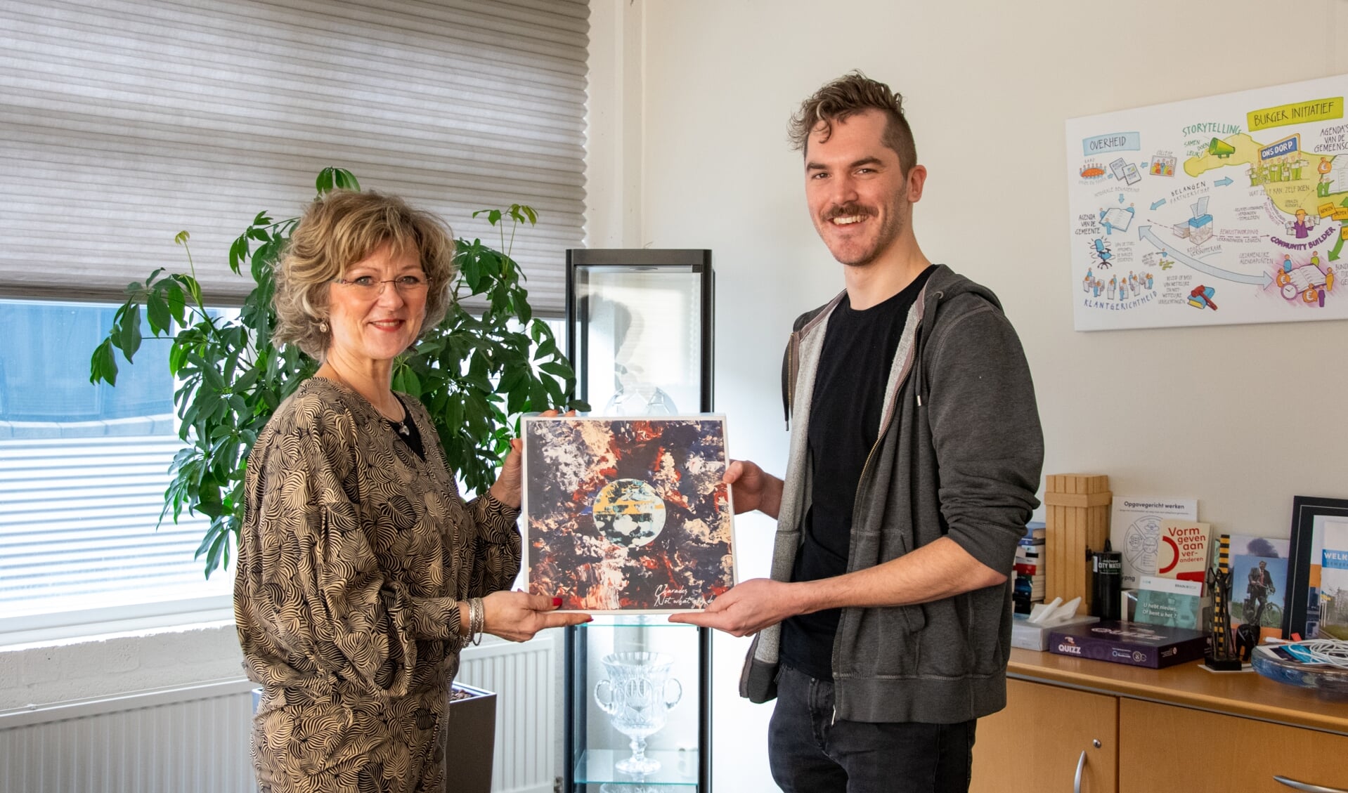 Burgemeester Ada Grootenboer-Dubbelman krijgt een exemplaar van het nieuwe album uit handen van bassist Frank Mastenbroek.  Foto: Sam Fish