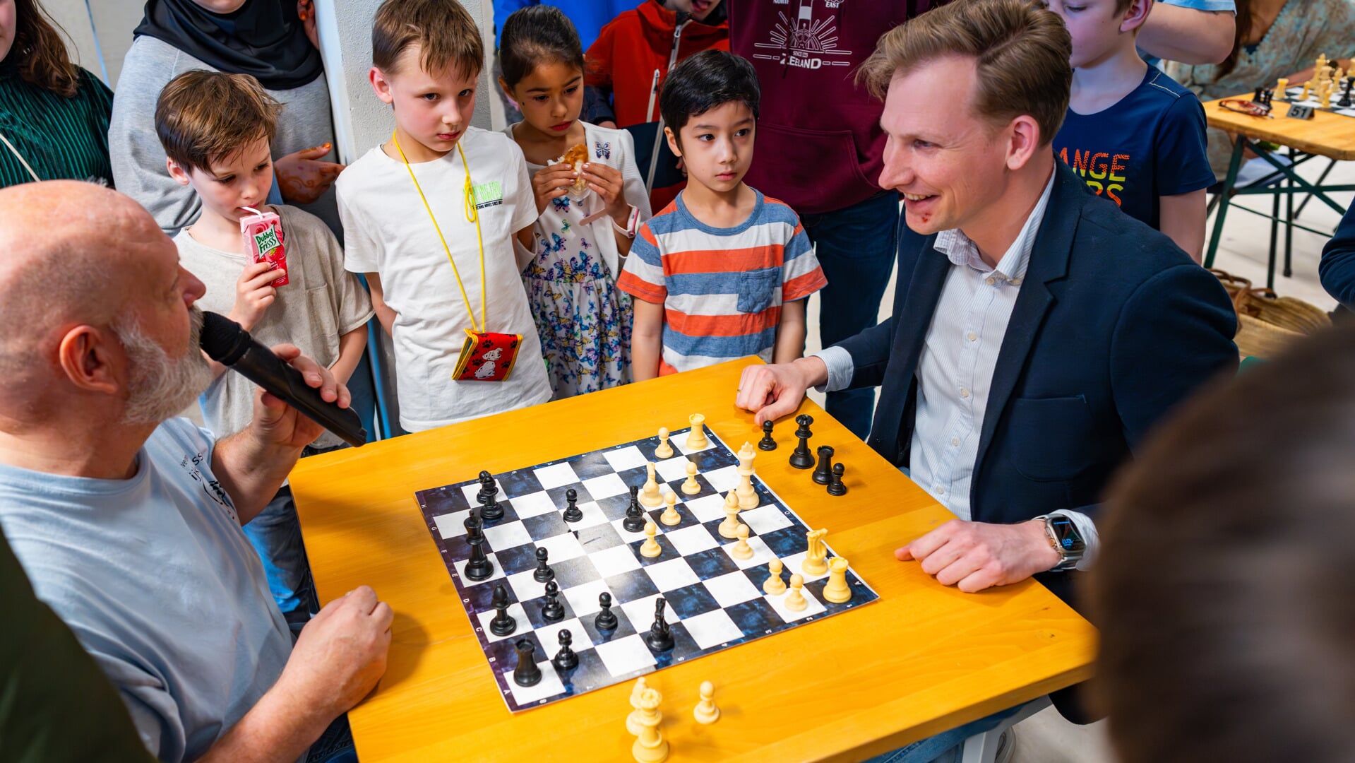 Voorzitter Eric de Lange (l) opent samen met wethouder Postma (r) het Jeugdschaaktoernooi. 