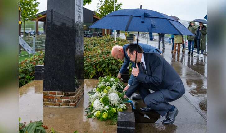Wethouder Hottentot legt samen met voorzitter Ad van der Bom een bloemstuk bij het monument van GHVV'13