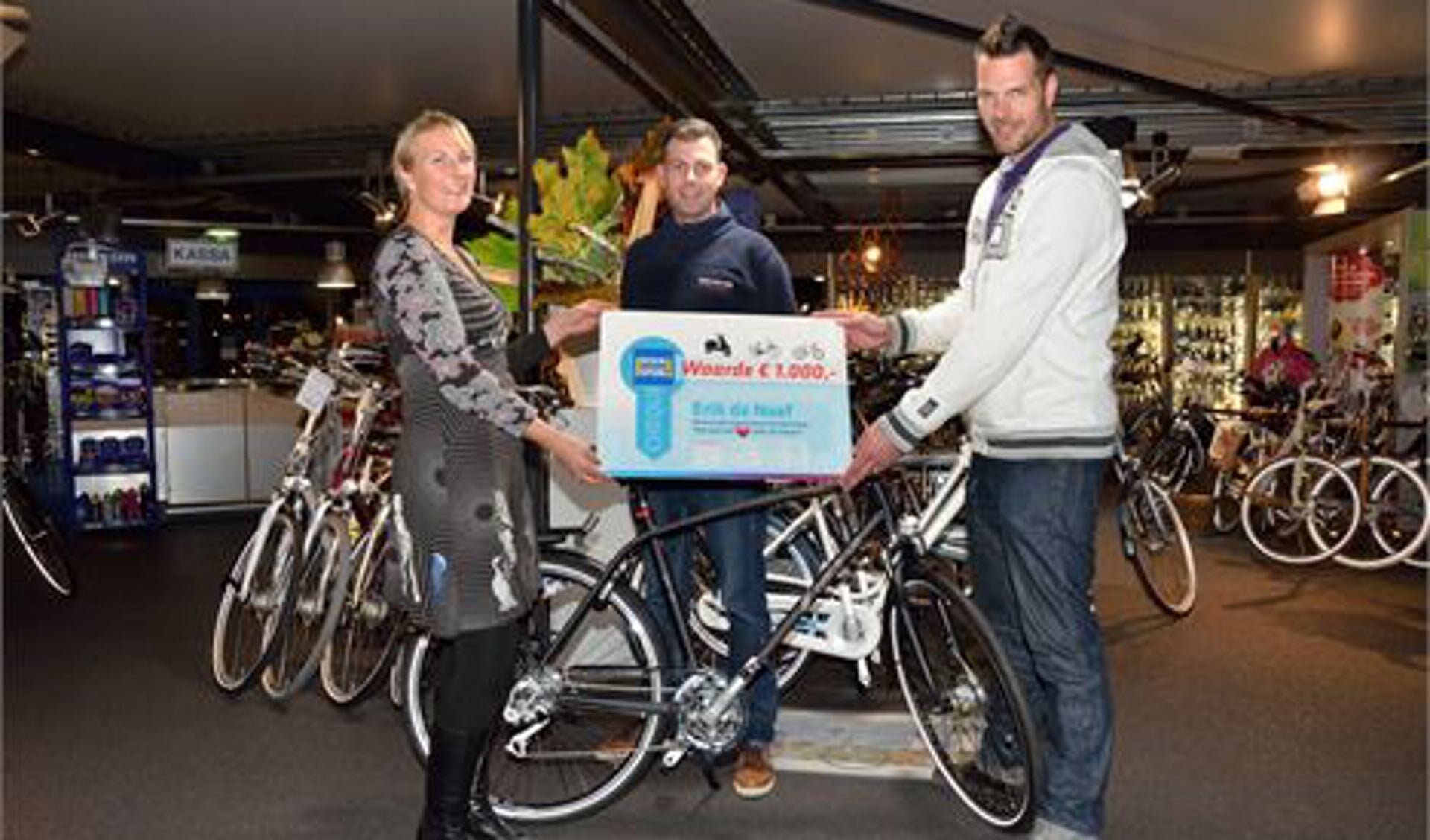Erik ontvangt uit handen van Esther Snelders van de Verkeersonderneming de cheque t.w.v. € 1.000,--, te besteden bij aankoop van een fiets.