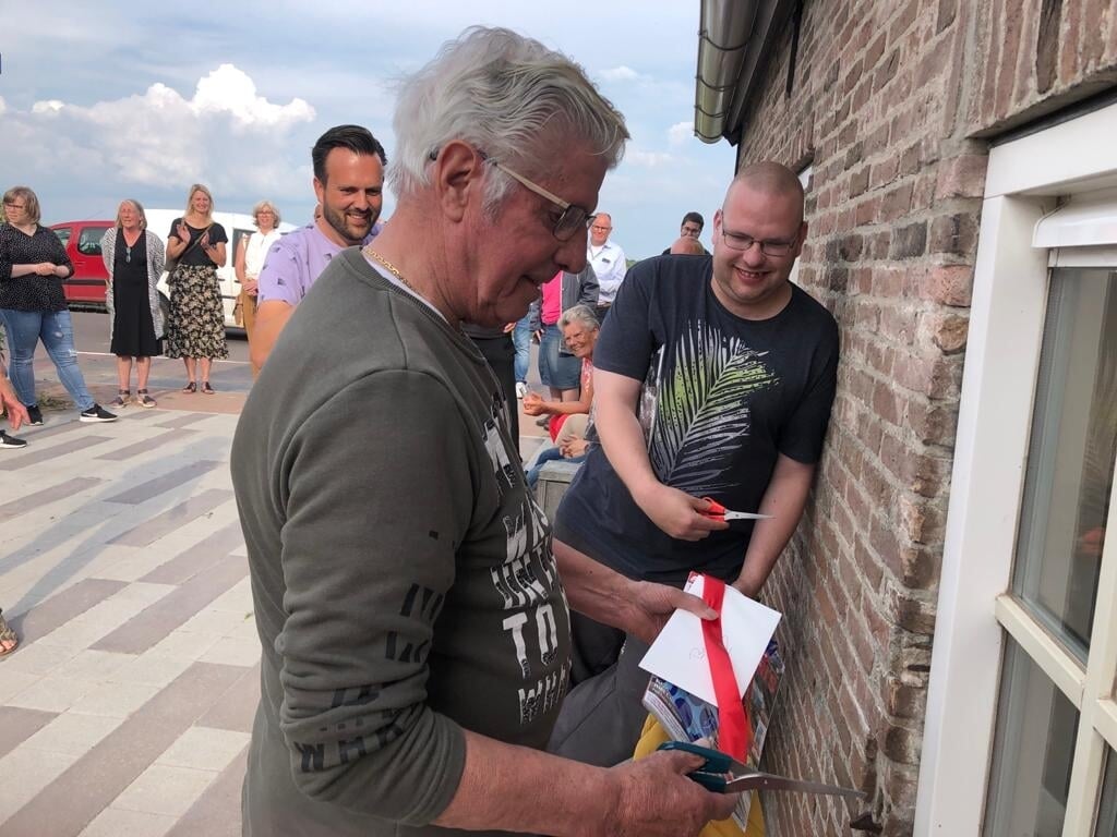 Het lint voor De Schuur wordt doorgeknipt door bewoners Ben en Maarten. (Foto: Privé)