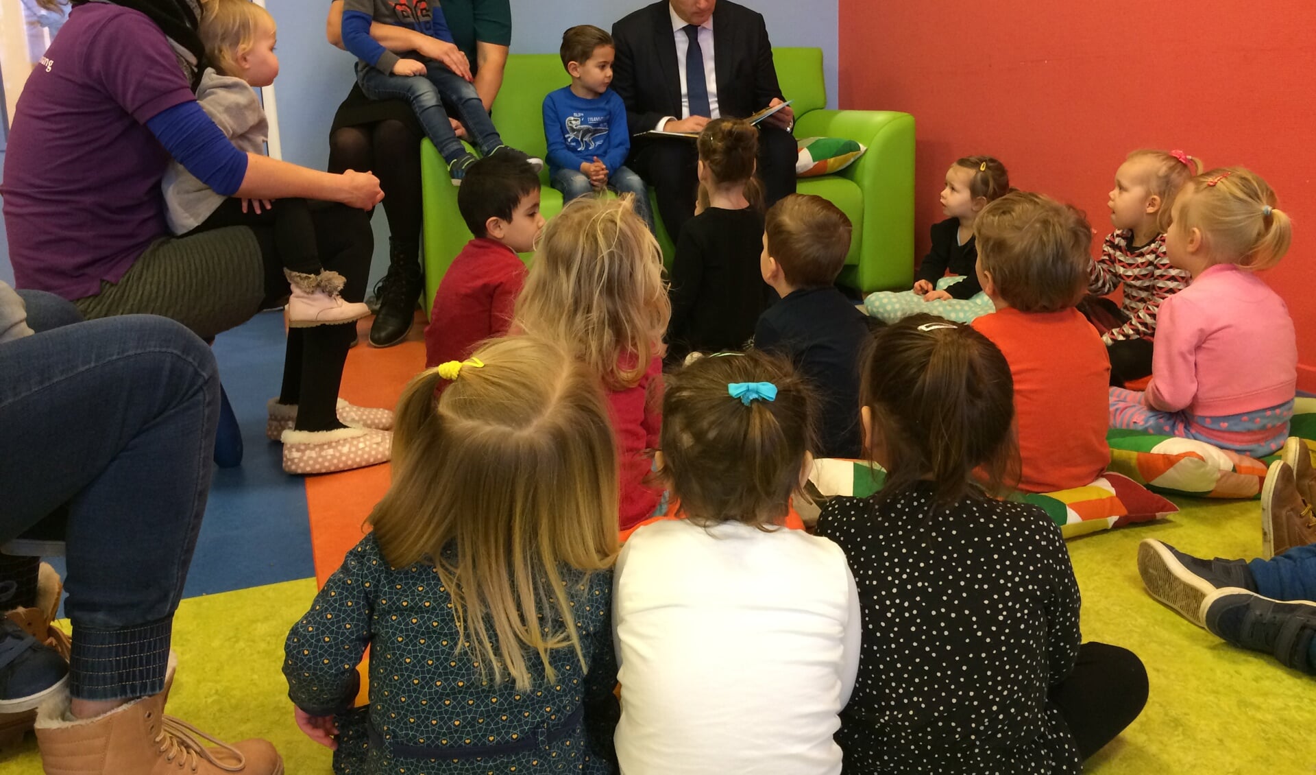 Burgemeester leest voor aan kinderen van zo kinderopvang.