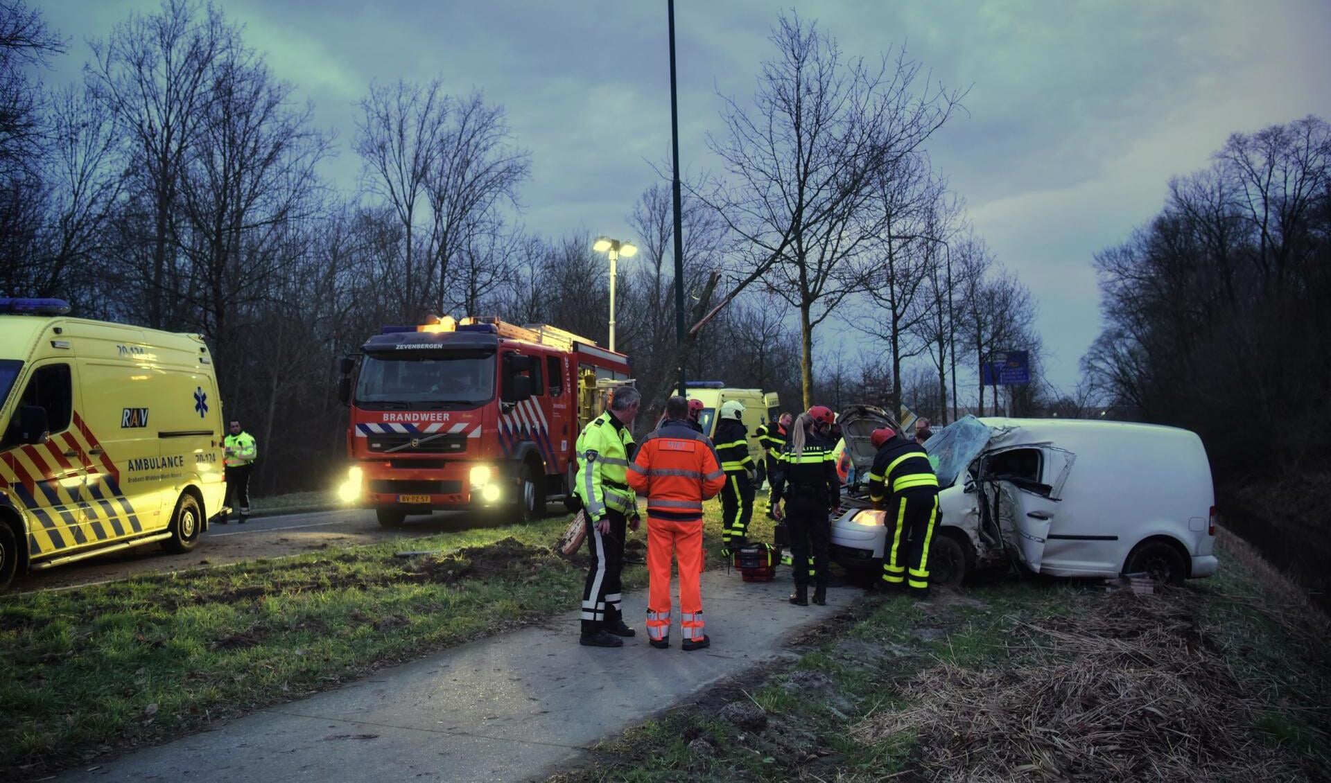 Hulpverleners bij de auto.