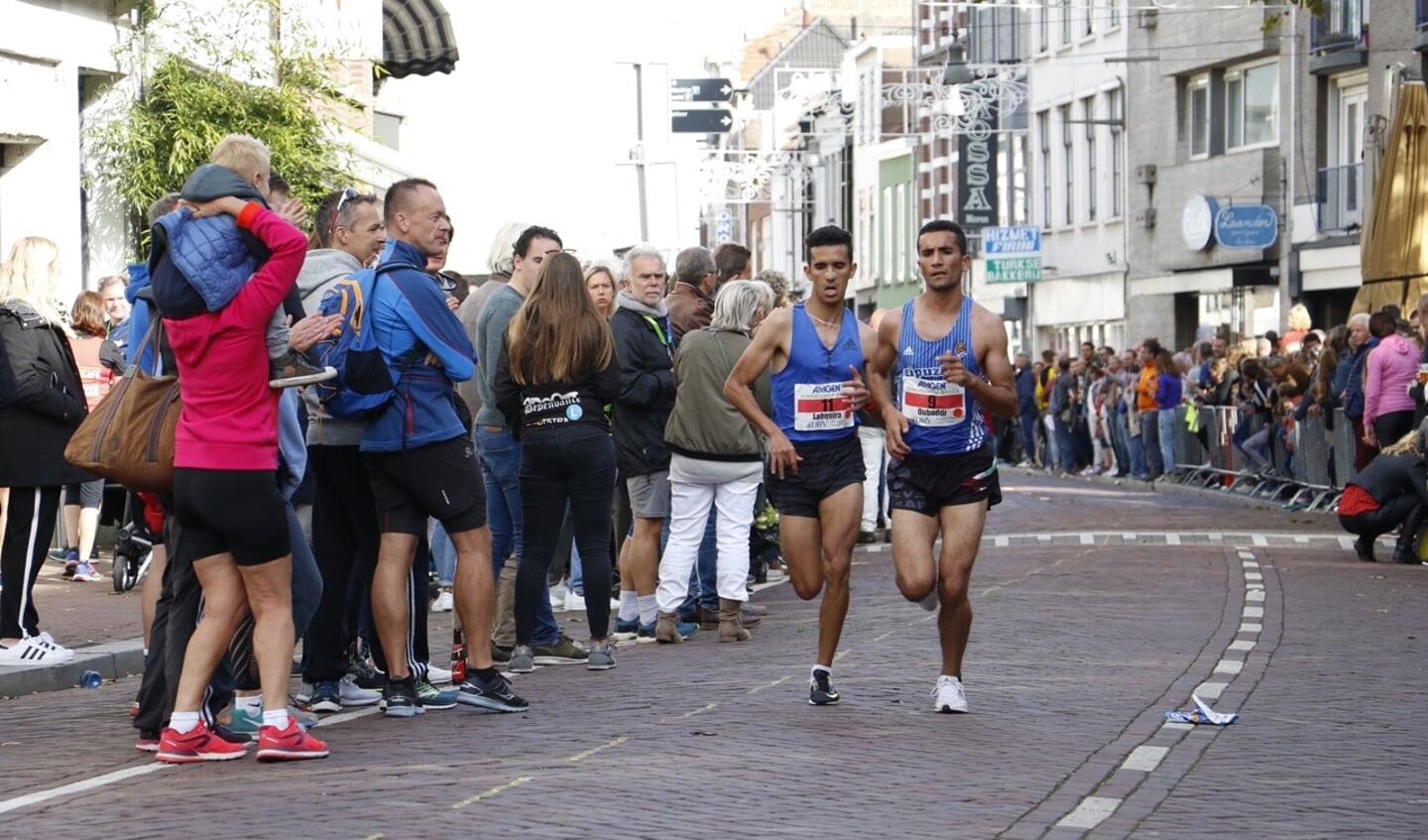 De kopgroep van de halve marathon rent door de Boschstraat.
