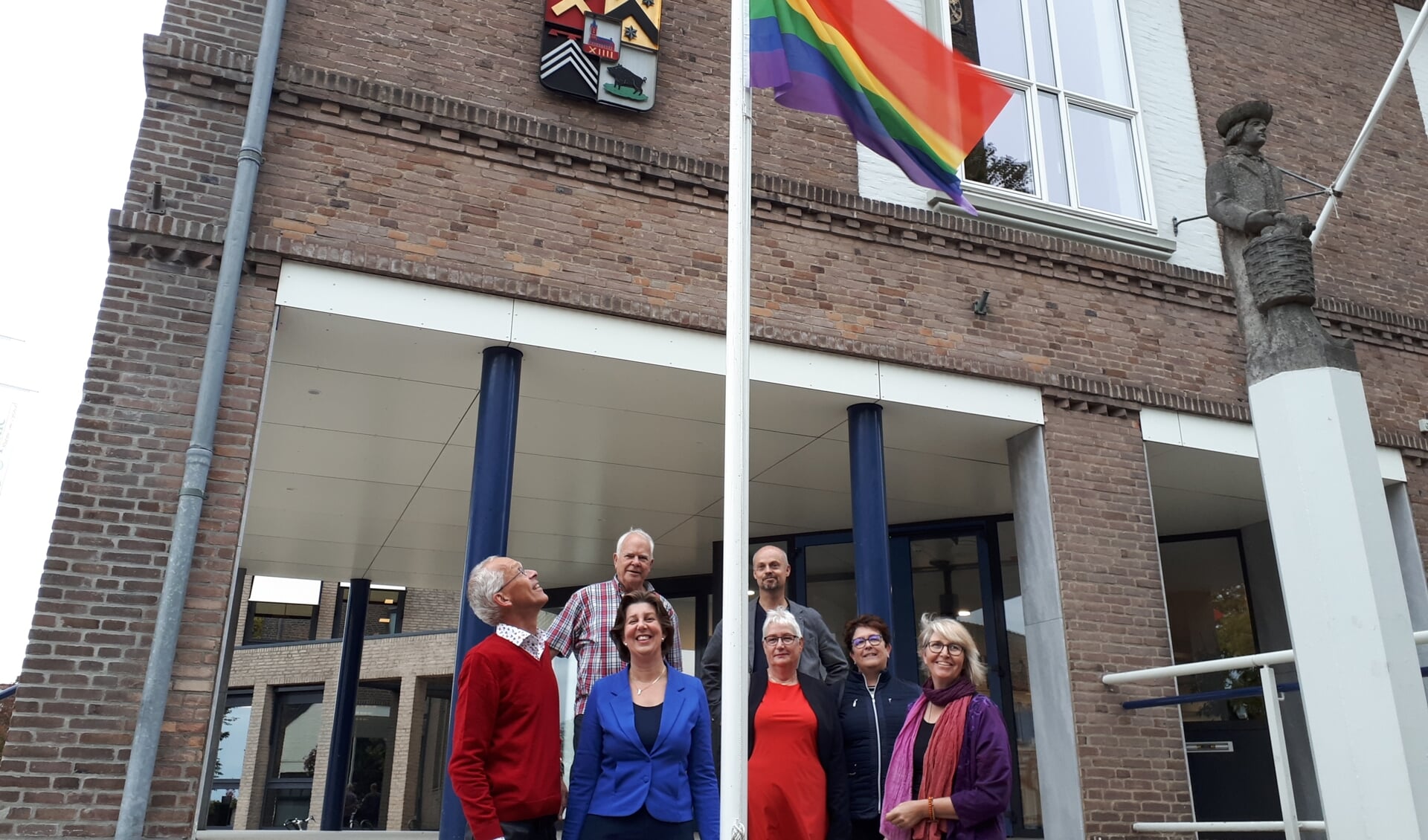 Wethouder Evertz (blauw jasje) met COC-vertegenwoordigers en D66-gemeenteraadslid Marc van Opstal bij de regenboogvlag in Kapelle.