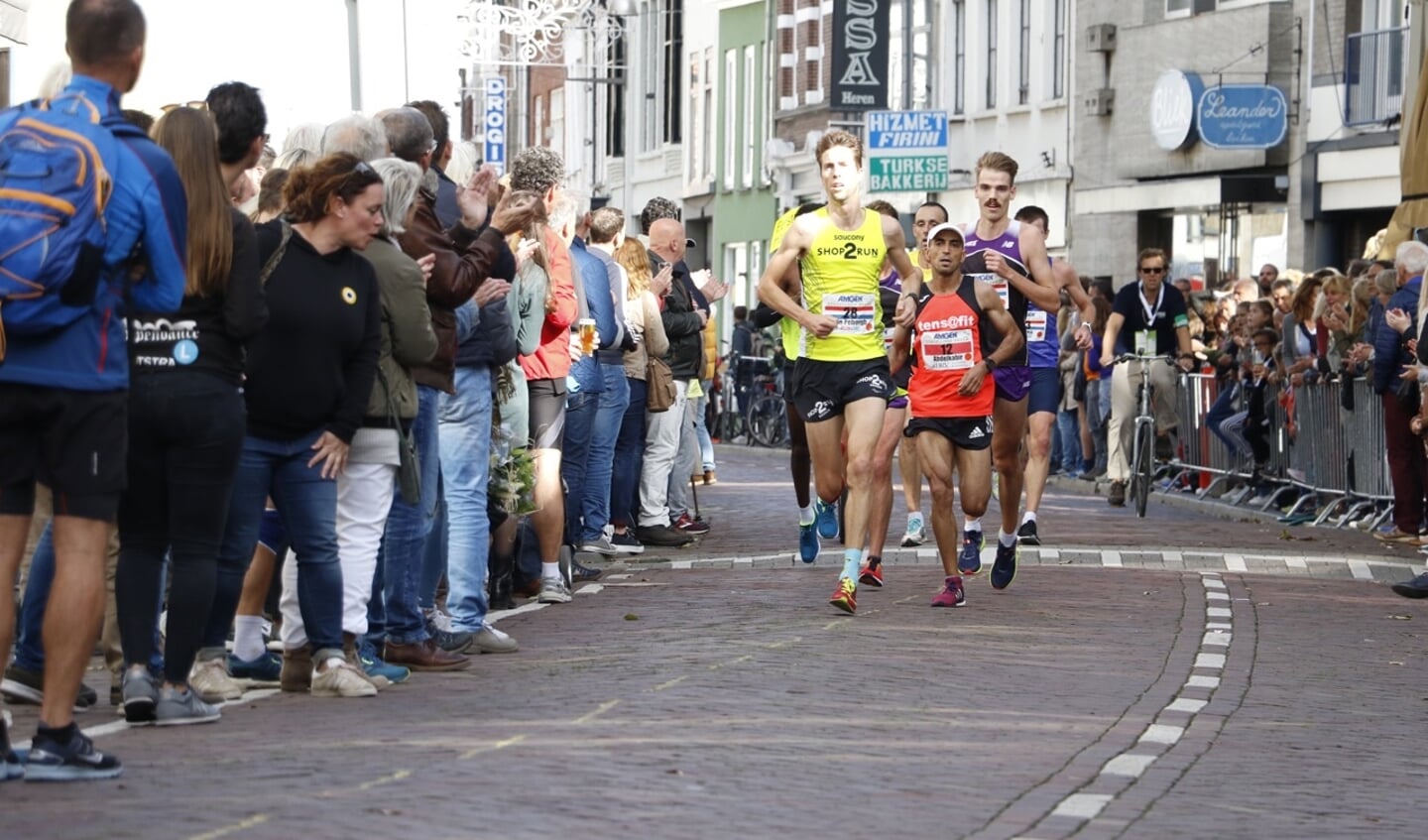 De kopgroep van de halve marathon rent door de Boschstraat.