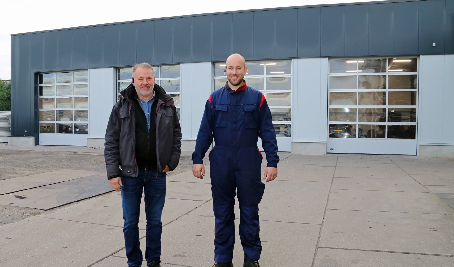 Vader Arie en zoon Wilbert de Kramer bij hun vernieuwde autobedrijf in Yerseke.
