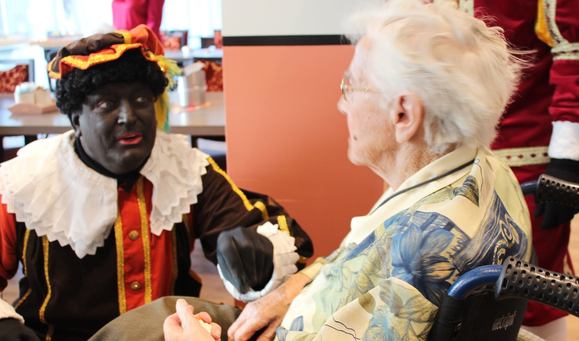 Piet geeft pepernoten aan een 100-jarige inwoner van De Vossemeren in Nieuw-Vossemeer