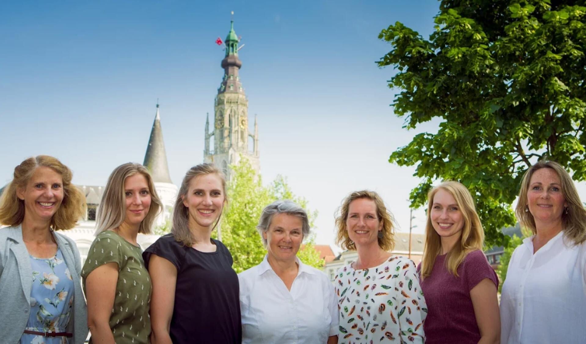 Fransje (midden) samen met haar collega's voor de Grote Kerk in Breda