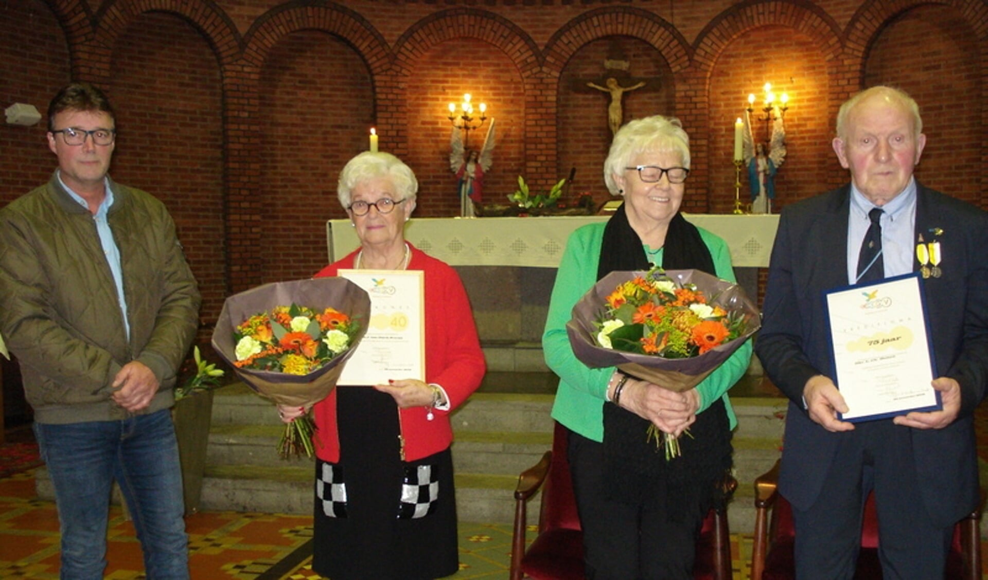 Jubilarissen Jo van Dijck (rood jasje) 40 jaar koorlid (en zoon Roger) en Leon Domen 75 jaar koorlid met vrouw Marie.