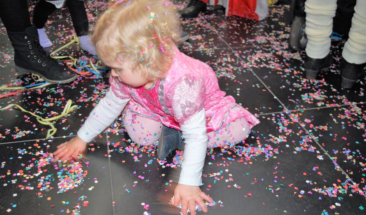 Isa van 18 maanden is gefascineerd door de confetti