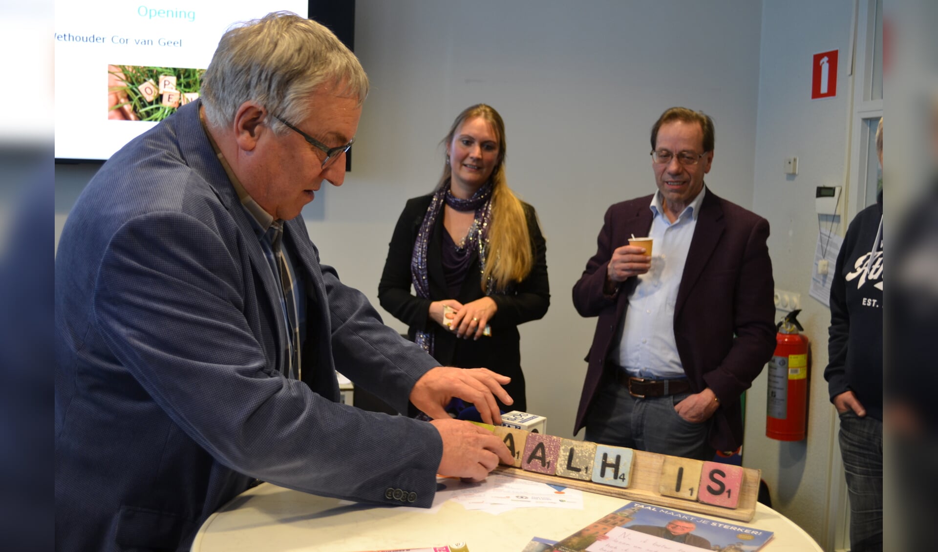 Wethouder Cor van Geel opende het Taalhuis door het woord te spellen op een taalplankje FOTO REMKO VERMUNT
