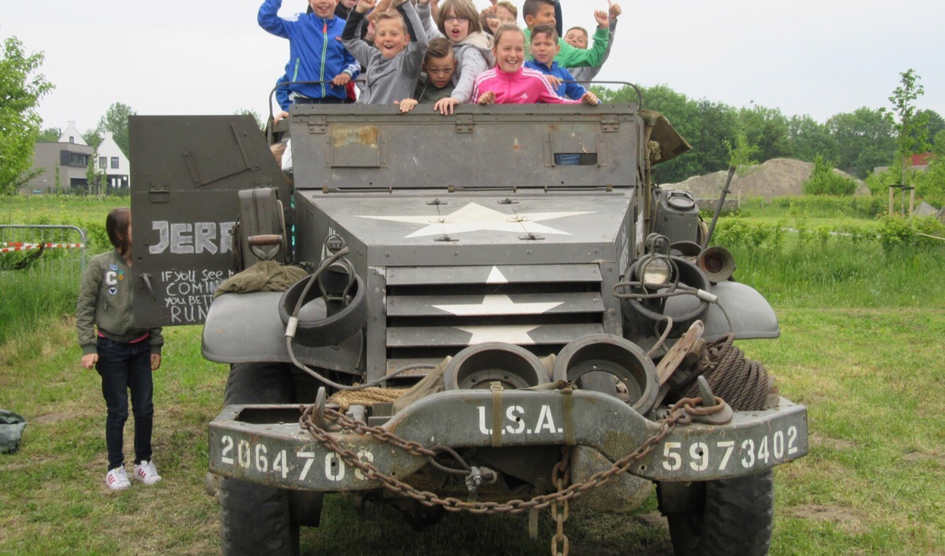 De kinderen van de Moolhoek uit Kapelle bij een legervoertuig van Vitality. 