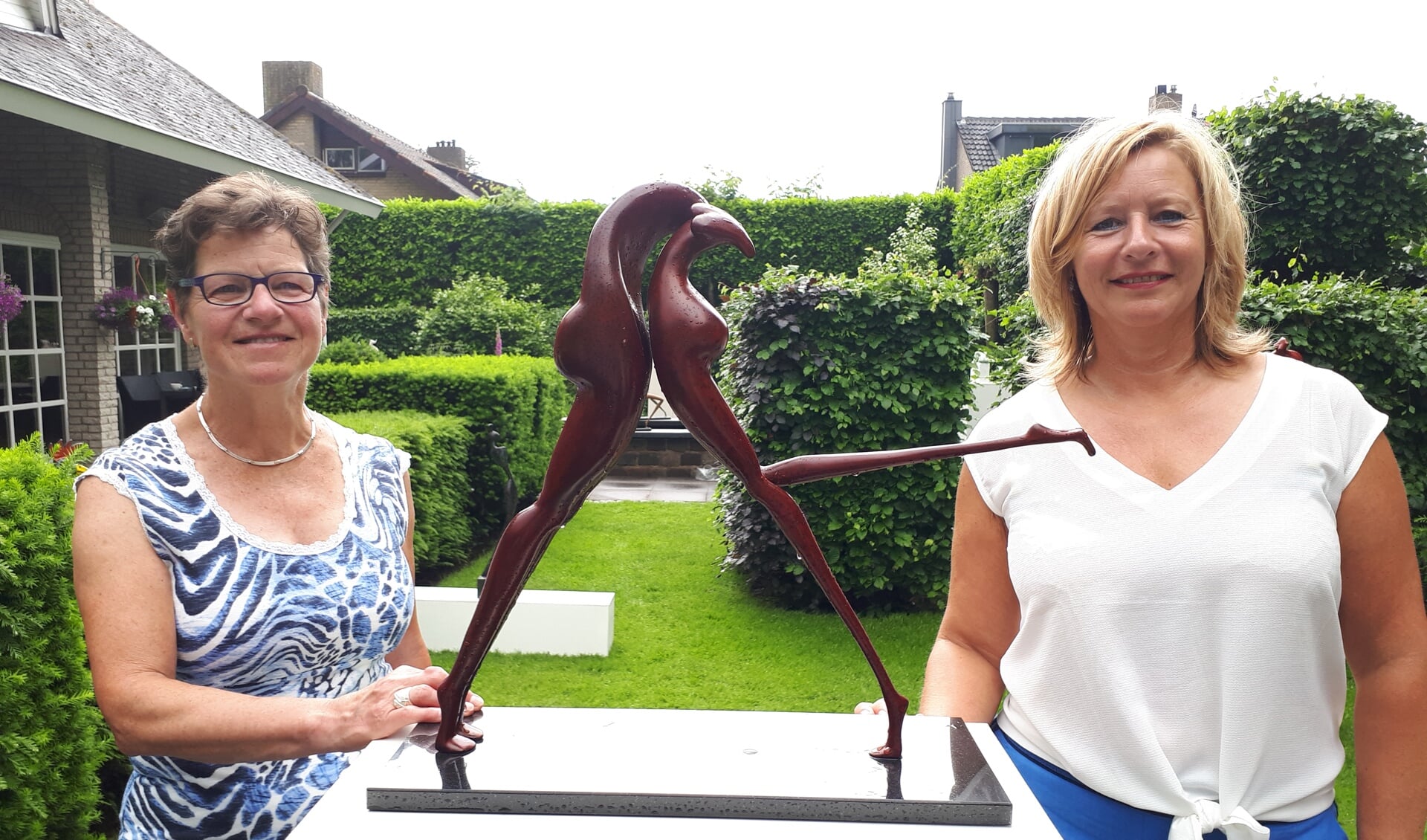 Gastvrouw Efrie van Moosdijk en kunstenares Yvonne Derijcke naast haar bronzen sculptuur ‘Passie’.
