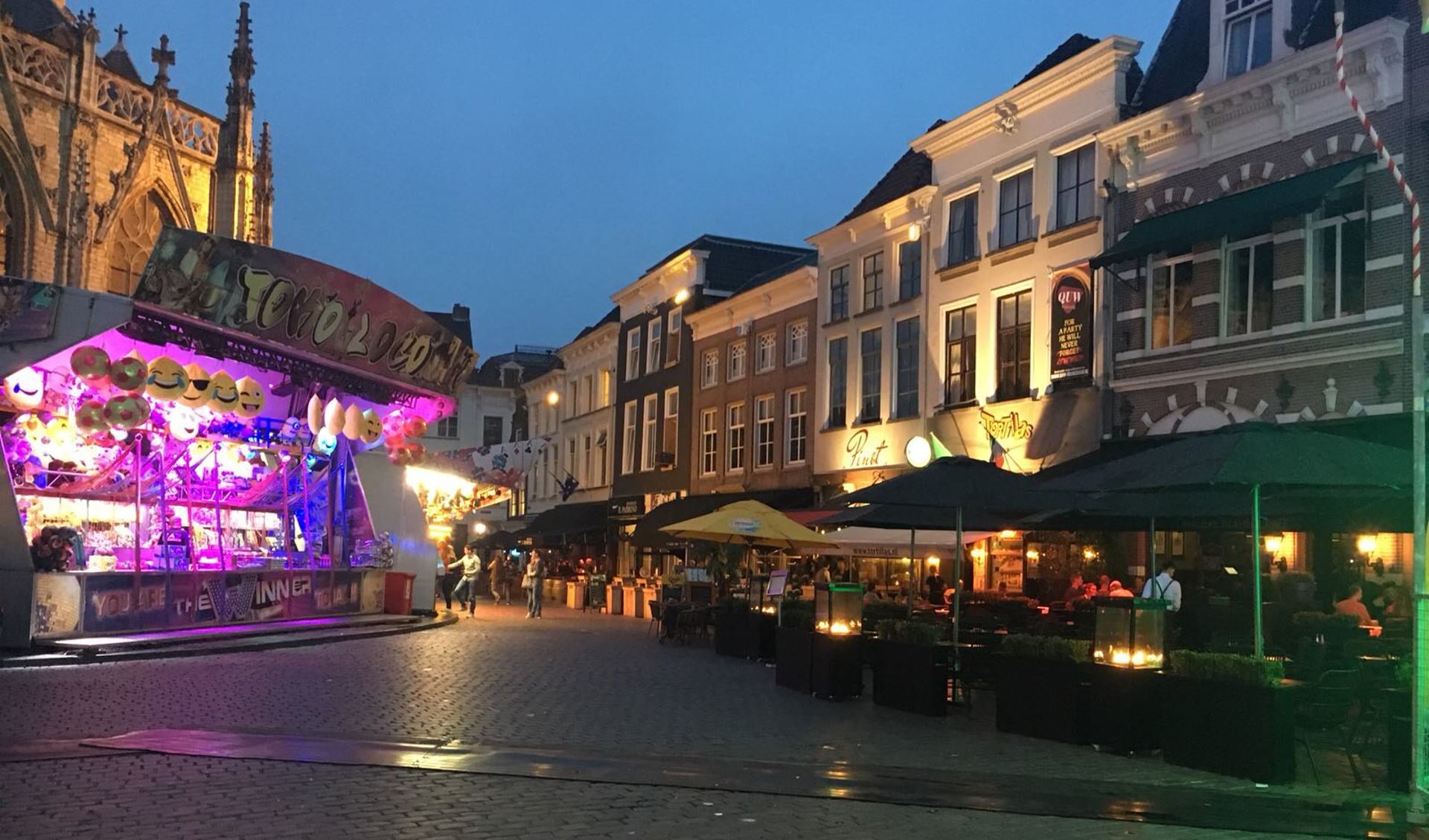 Kermisattracties aan de voet van de Grote Kerk tijdens de familiekermis.