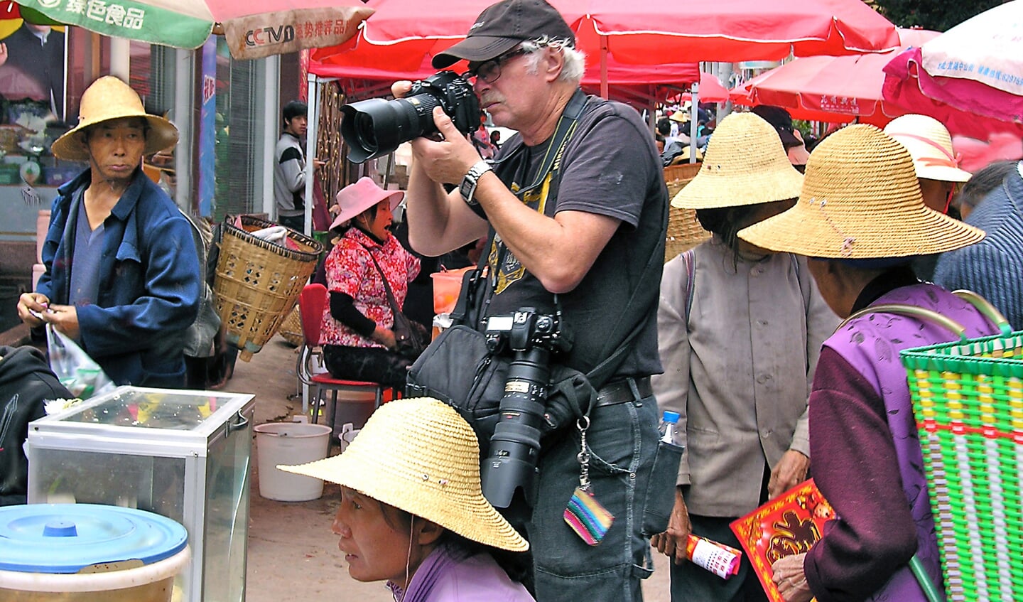Jacques Plouvier aan het fotograferen op een marktje in het Chinese Yunnan.
