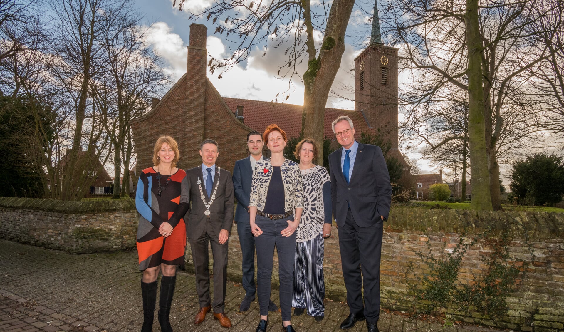 De dorpsraad met rechtsvoor voorzitter Lisette Booij, burgemeester Huub Hieltjes en rechts commissaris van de koning Han Polman.