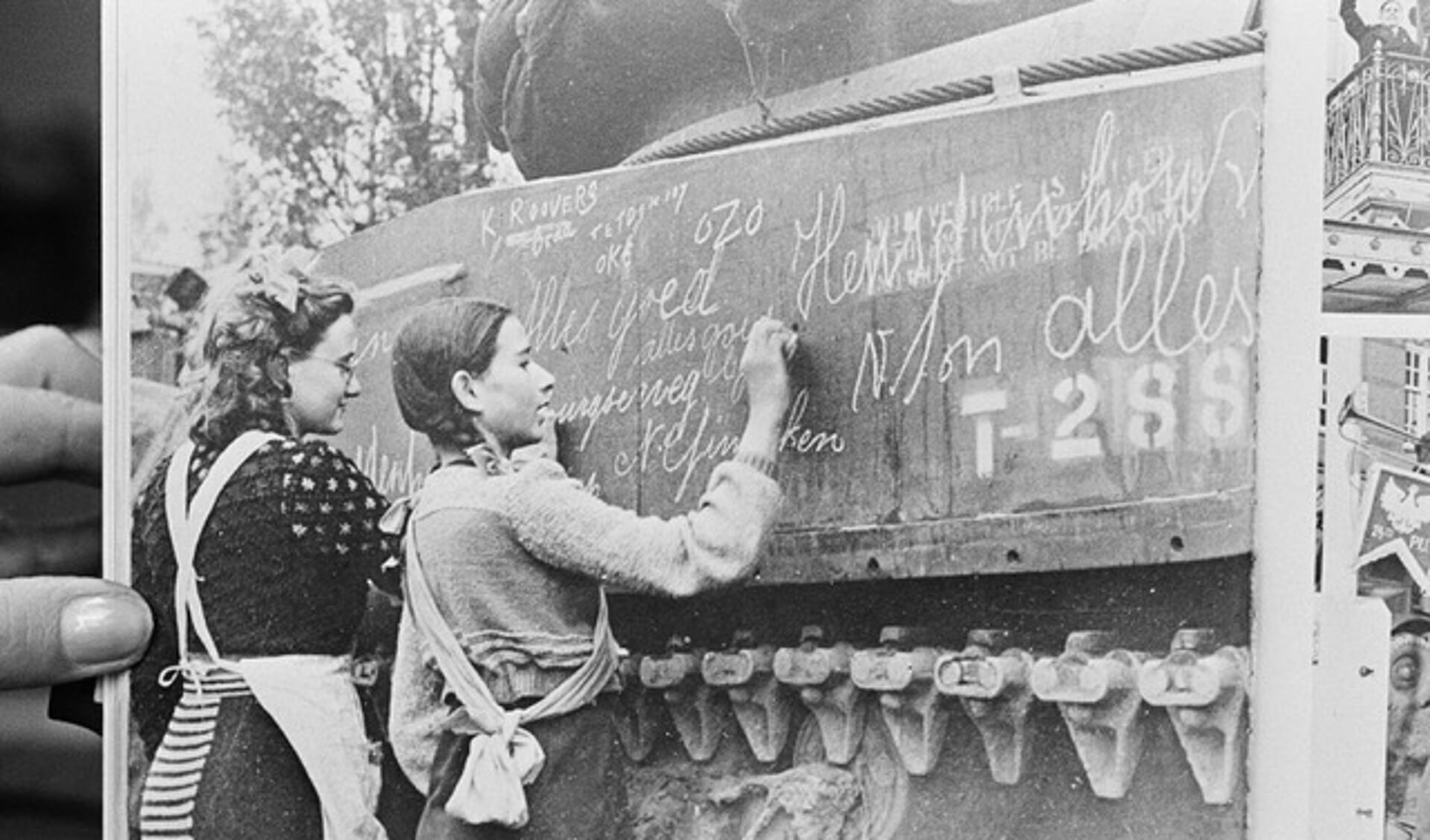 Ria Welten en Jacqueline Dymphna Cornelia (Ineke) van Wijck zetten een boodschap op een Poolse tank tijdens de bevrijding in Breda.