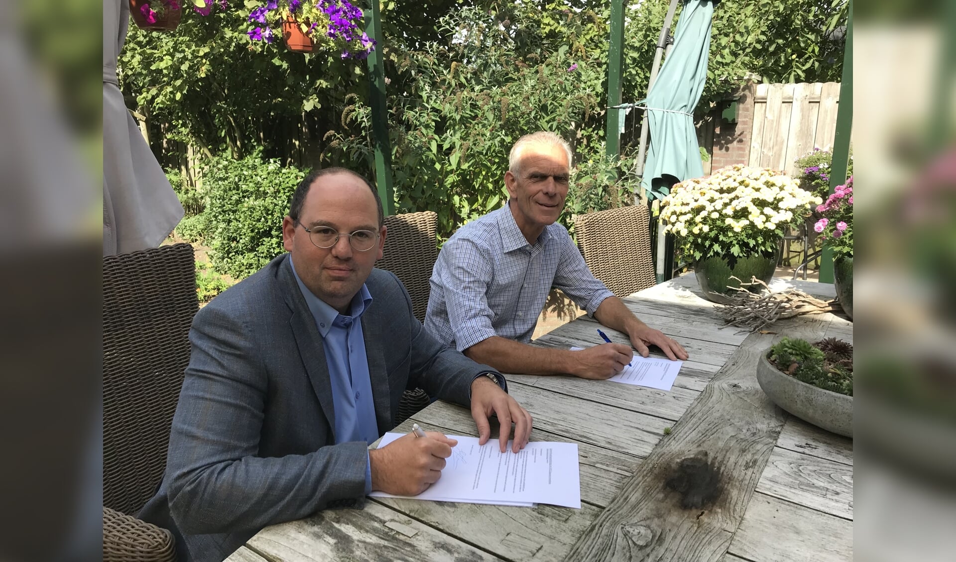 Barry van de Luijtgaarden en Kees Kools ondertekenen  de overeenkomst.