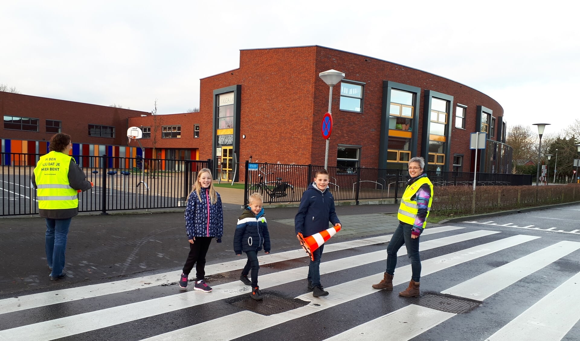 Verkeersouders Heidi de Jong (l) en Jeanet Steenbeek helpen kinderen met oversteken.