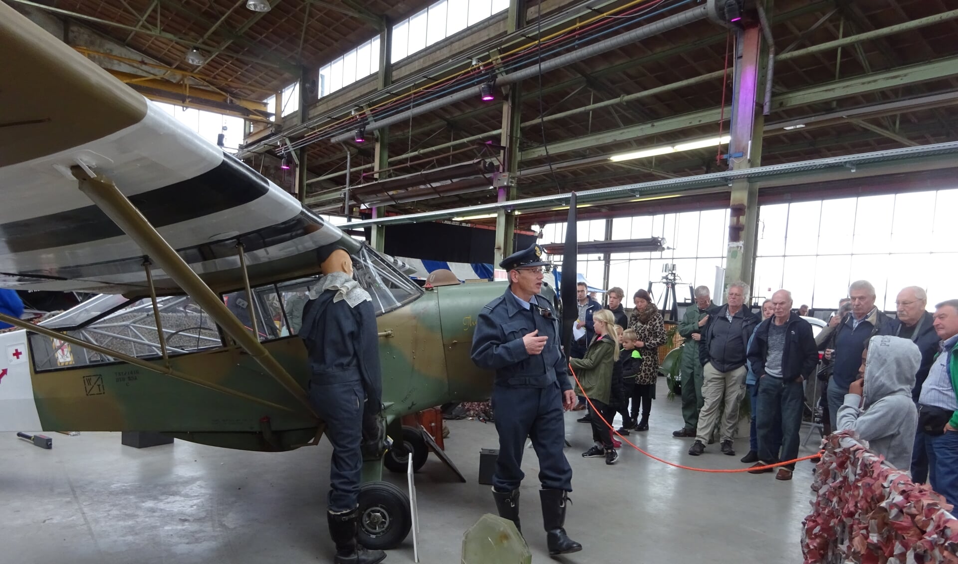 Bezoekers van War, Wings & Concrete krijgen uitleg over een oorlogsvliegtuig. FOTO MARIELJA TEN BRUGGENCATE
