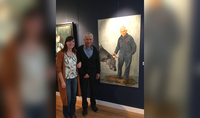 Natalie Koeken poseert samen met haar oom Rinus van Bergen bij haar schilderij 'Nonkeltje II'.