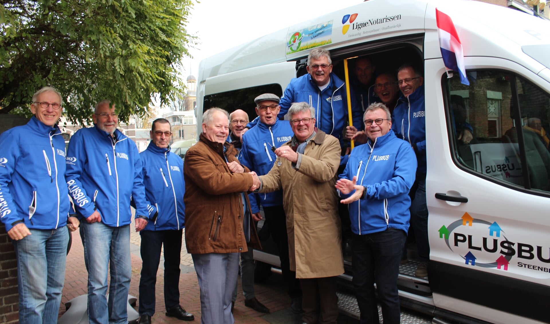 Het team chauffeurs van de PlusBus in Steenbergen krijgt de sleutel van Adri van der Hoeven voor de nieuwe bus.
