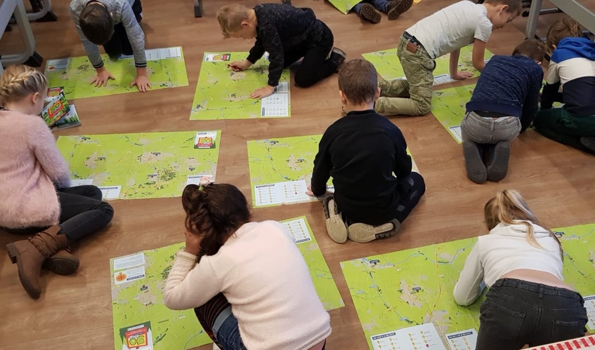 Kinderen bekijken de plattegrond die in het 50 dingen boekje zit.
