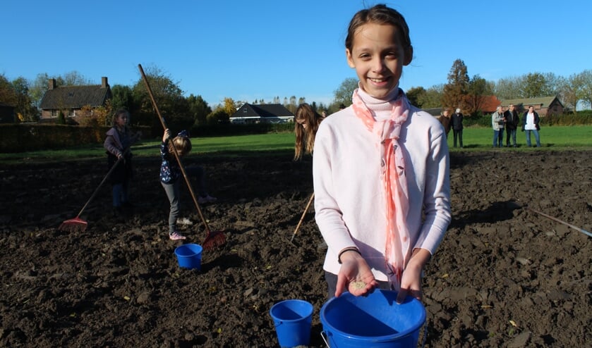 Alexa (9) van de Regenboogschool toont de zaadjes voor de bloemen die gaan groeien op de Vlinderidylle.