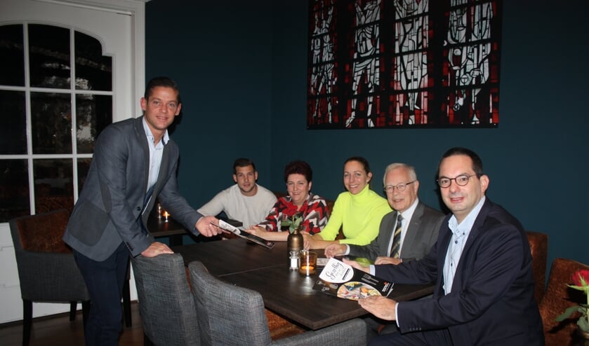Ruud de Weert overhandigt een brochure aan collega-horecaondernemers, wethouder Kielman en burgemeester Adriaansen.
