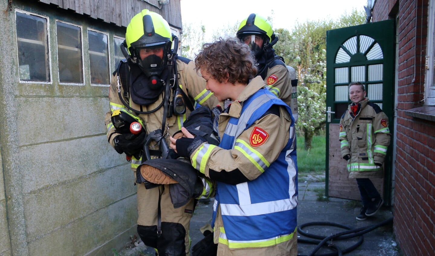 Kinderburgemeester Hessel helpt brandweerlieden een 'slachtoffer' in veiligheid te brengen. 