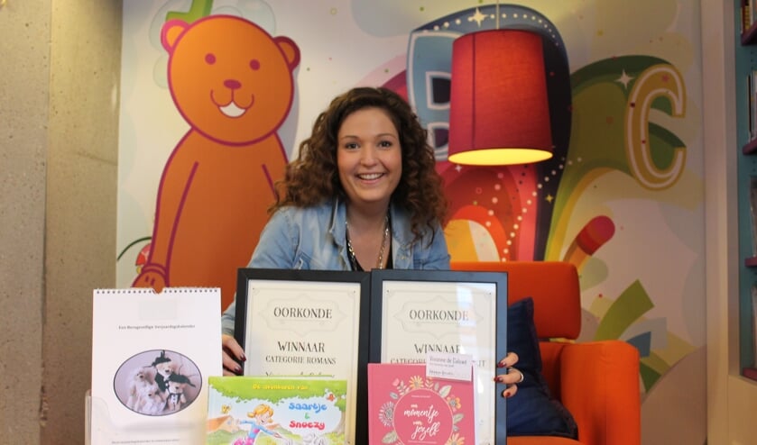 Vivianne de Caluwé met haar boeken en teddyberen kalender in bibliotheek Het Markiezaat Steenbergen.