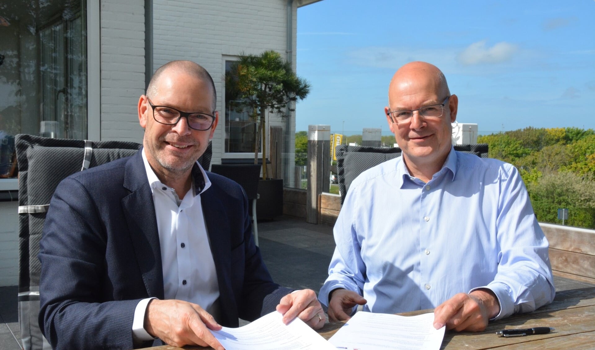 Jules van Leijden (l) van de Rabobank en Kustmarathon-voorzitter Chris Simons met het nieuwe contract.