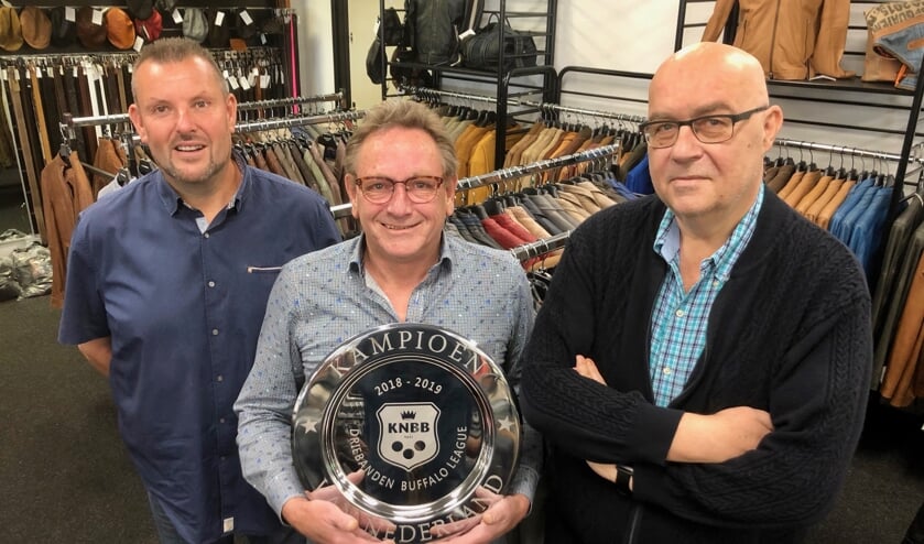 Ad Braspenning van L&B Ledermode met de kampioensschaal, links Gerwin Valentijn, rechts Kees Broos. FOTO JOHAN WAGENMAKERS