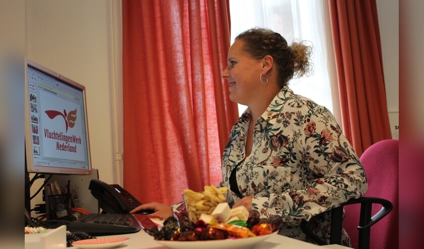 Monirah Schep van VluchtelingenWerk Steenbergen biedt bezoekers verschillende lekkernijen aan tijdens Bakkie Doen.
