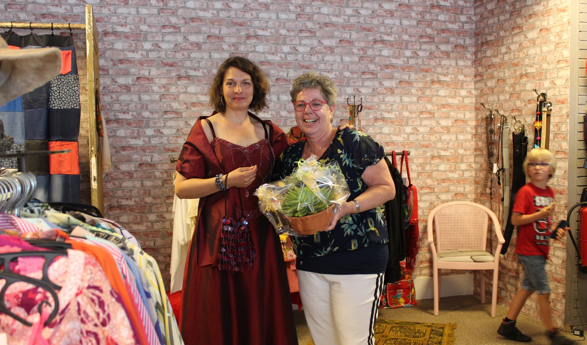 Marina Fidder van gemeente Steenbergen past een galajurk in De Ontmoetingswinkel van Rian Liefhebber.