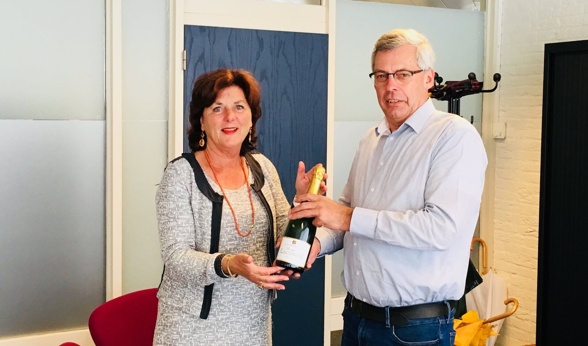Burgemeester Leny Poppe-de Looff en  initiatiefnemer Ad Daamen vieren de succesvolle uitrol van buurtpreventie met champagne. 