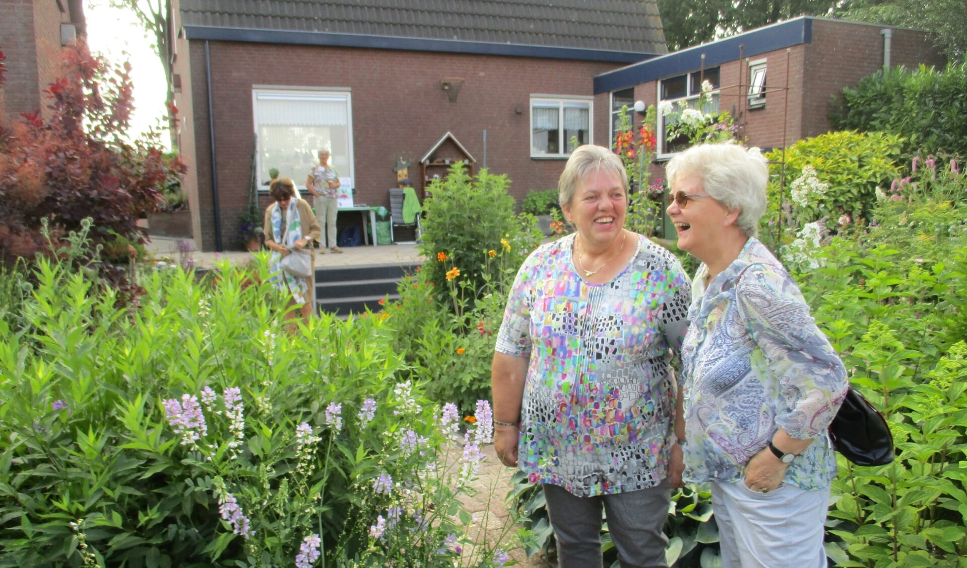 Marian Ooijen (links) in haar prachtige tuin.