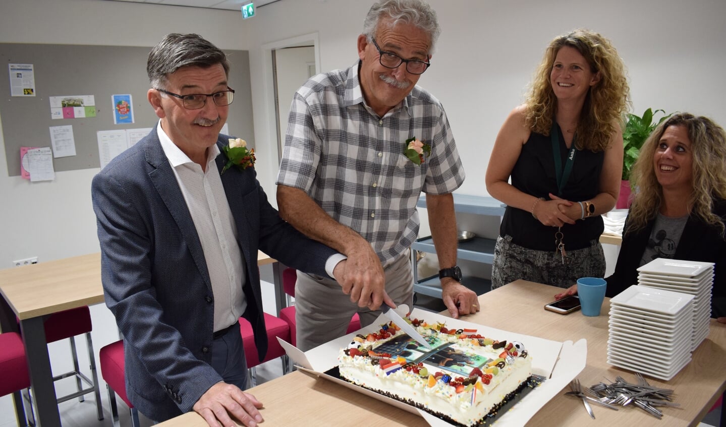 Bij afscheid hoort taart. Ton van Giels (links) en Frans Klijs hanteren samen het mes. FOTO STELLA MARIJNISSEN
