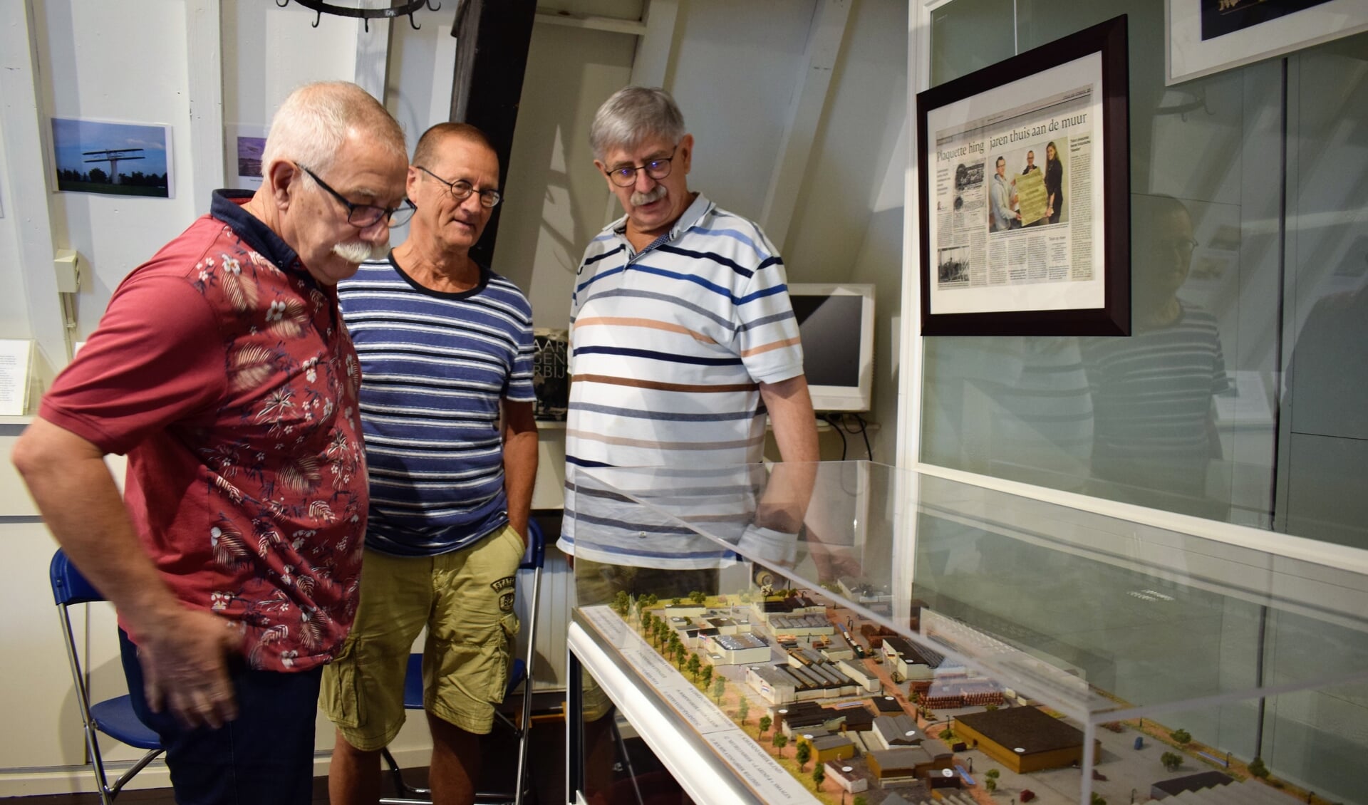 Van links naar rechts Anton Prins, Ton Jorna en Toon Vissers in het Streekmuseum Etten-Leur bij de maquette van het industrieterrein met daarop ‘hun’ drukkerij Roto Smeets. FOTO STELLA MARIJNISSEN
