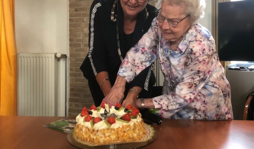 Samen met burgemeester Jobke Vonk-Vedder snijdt mevrouw Doomen de taart aan. Foto's: Johan Wagenmakers