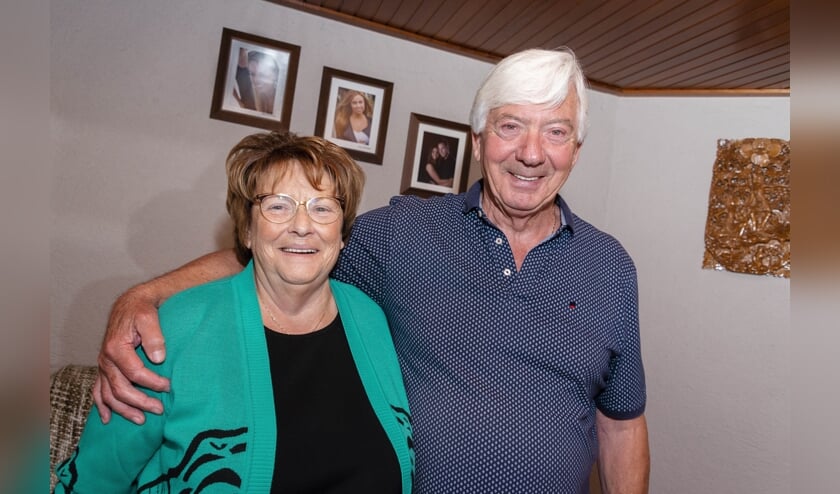 Het jubilerende echtpaar poseert bij de foto's van de kleinkinderen.