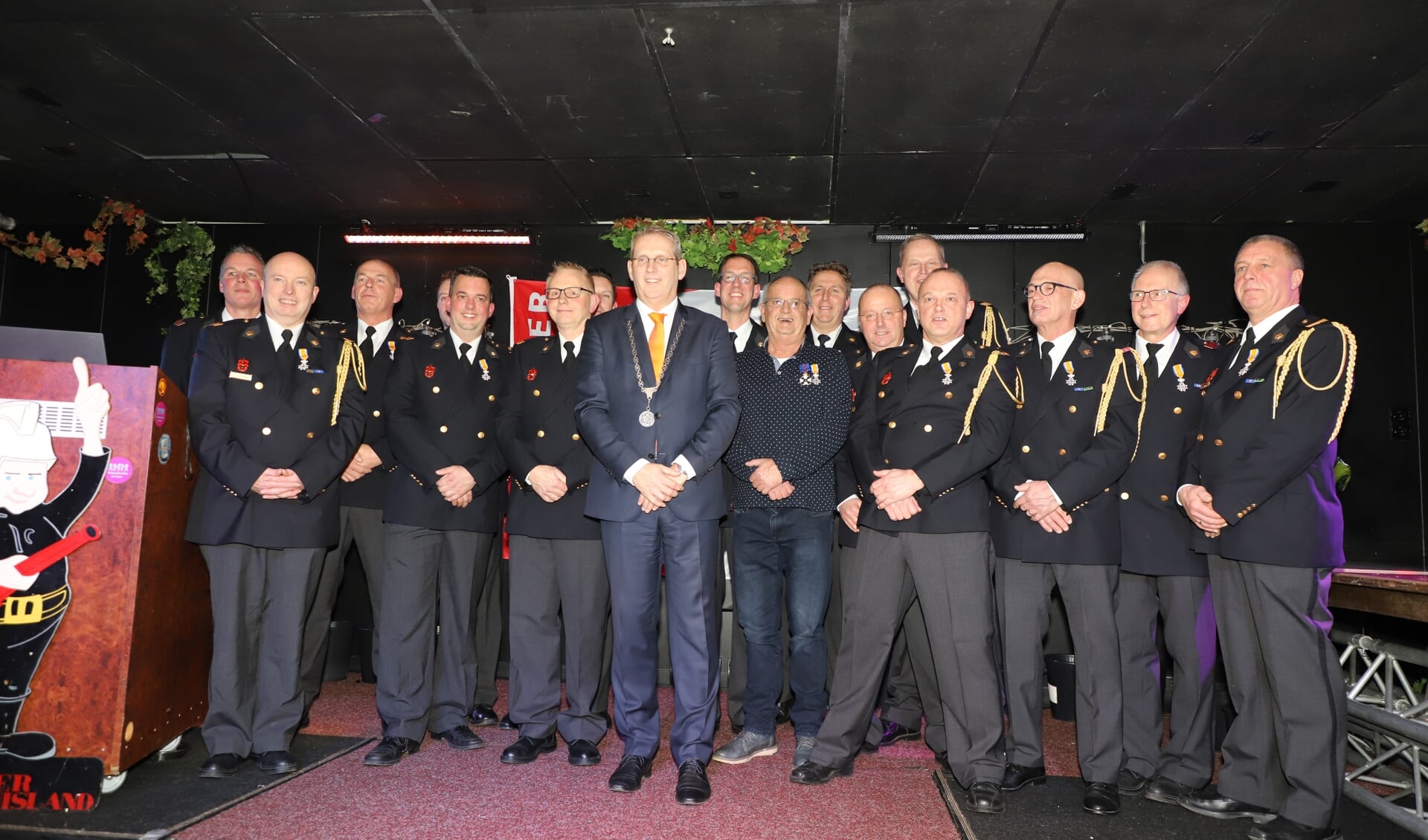 De gedecoreerde brandweerlieden poseren met burgemeester Ruud van den Belt. 