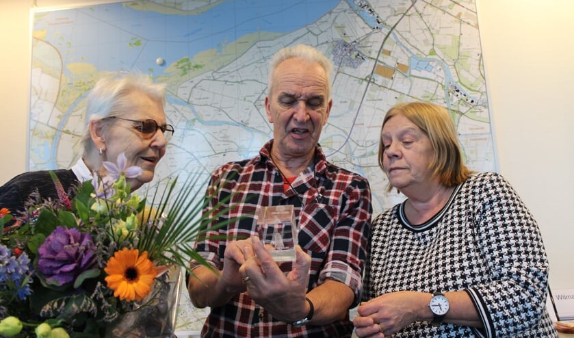 Oud-molenaar Lodi Baauw kijkt naar de glassculptuur, samen met zijn vrouw, die hij van wethouders Baartmans kreeg.