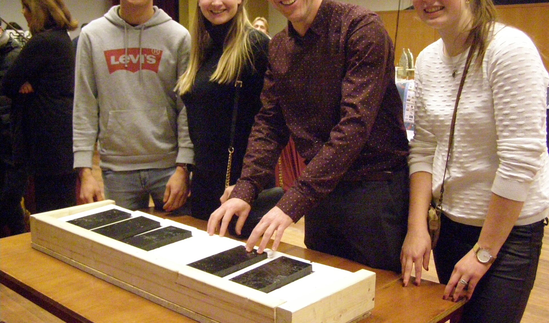 Wethouder Twan Zopfi bespeelt het door studenten ontworpen prototype van een klavier.
