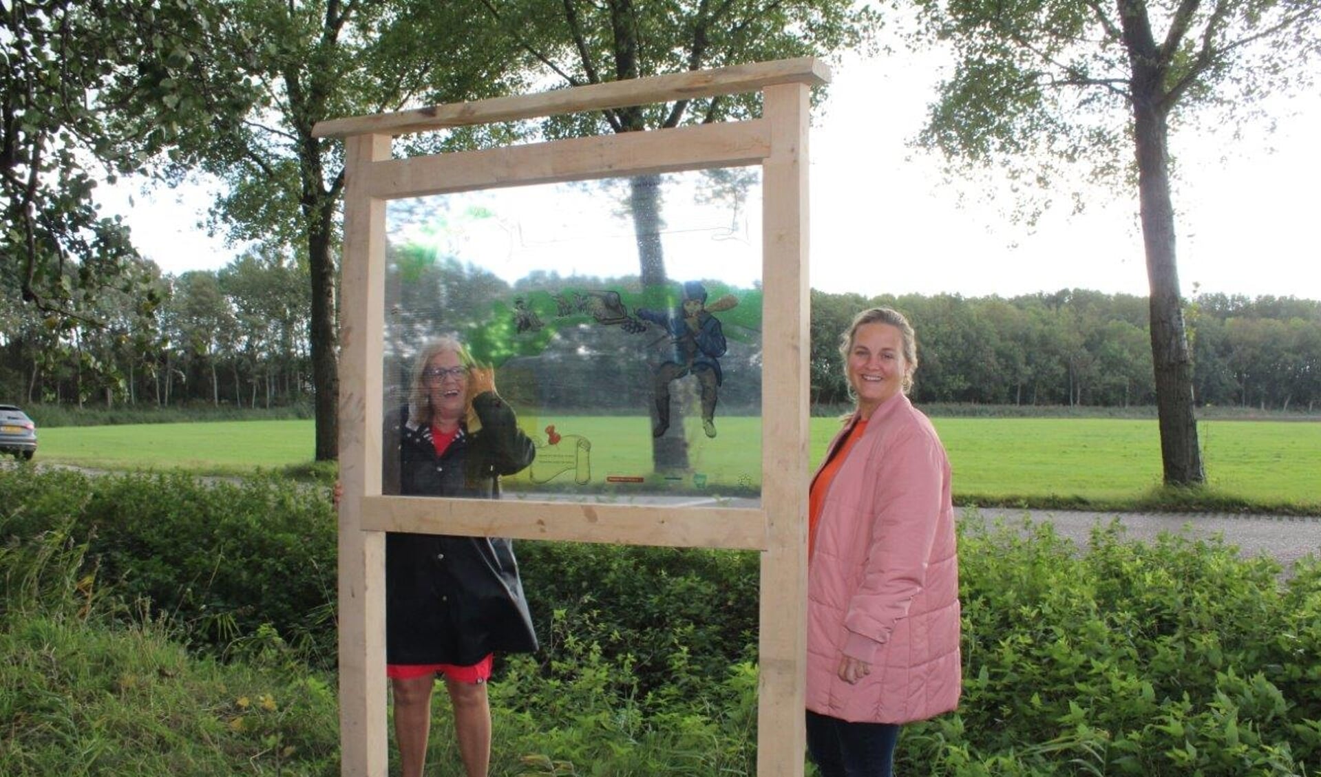 De wethouders Wilma Baartmans en Esther Prent bij het paneel aan de Westlandse Langeweg. 