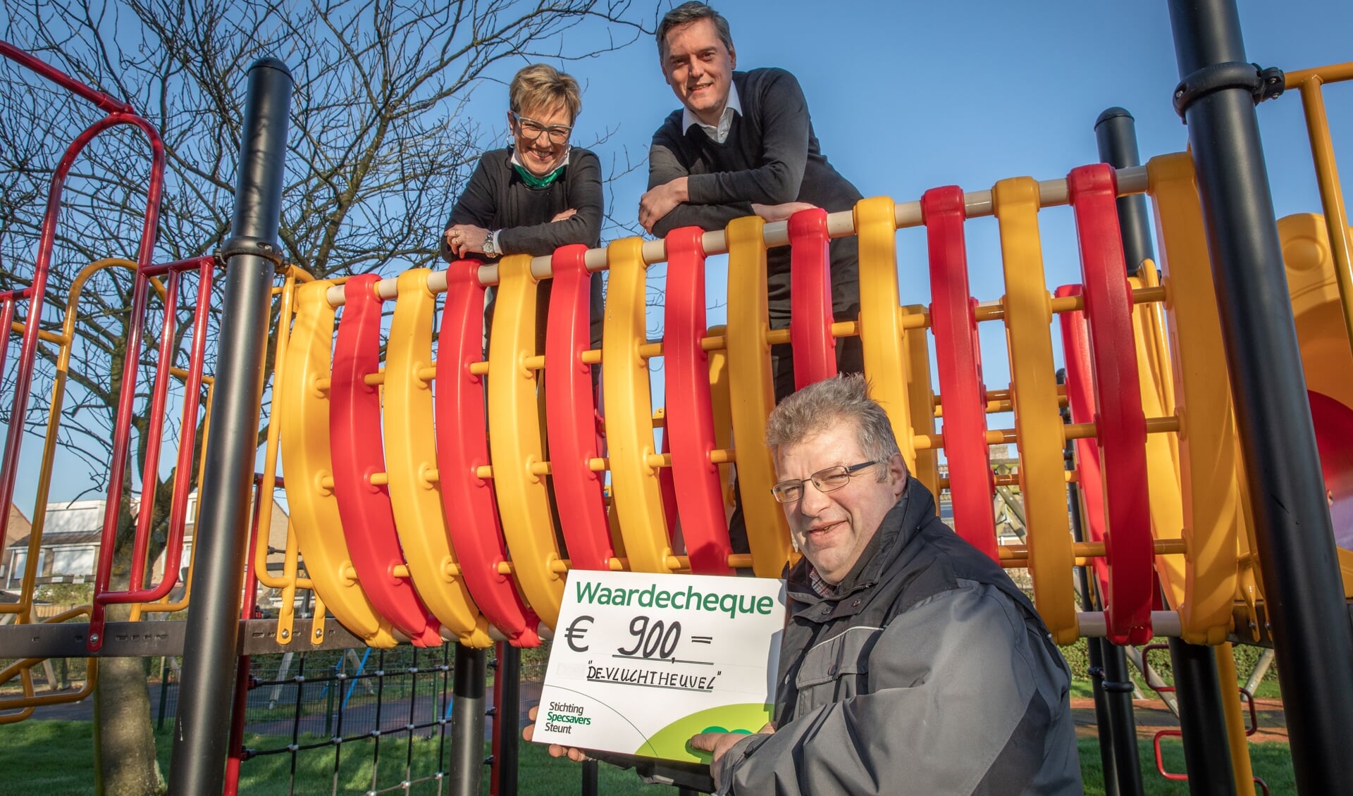 Stichting Specsavers Steunt steunt speeltuin 'de vluchtheuvel' uit Nieuwdorp met een waardecheque; bestuurslid Sam van Gurp neemt de cheque in ontvangst van Diana van Bavel en Wouter de Groot