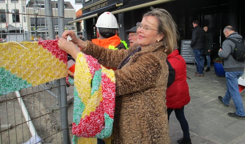 Wethouder Désirée Brummans hangt de sjaal op.